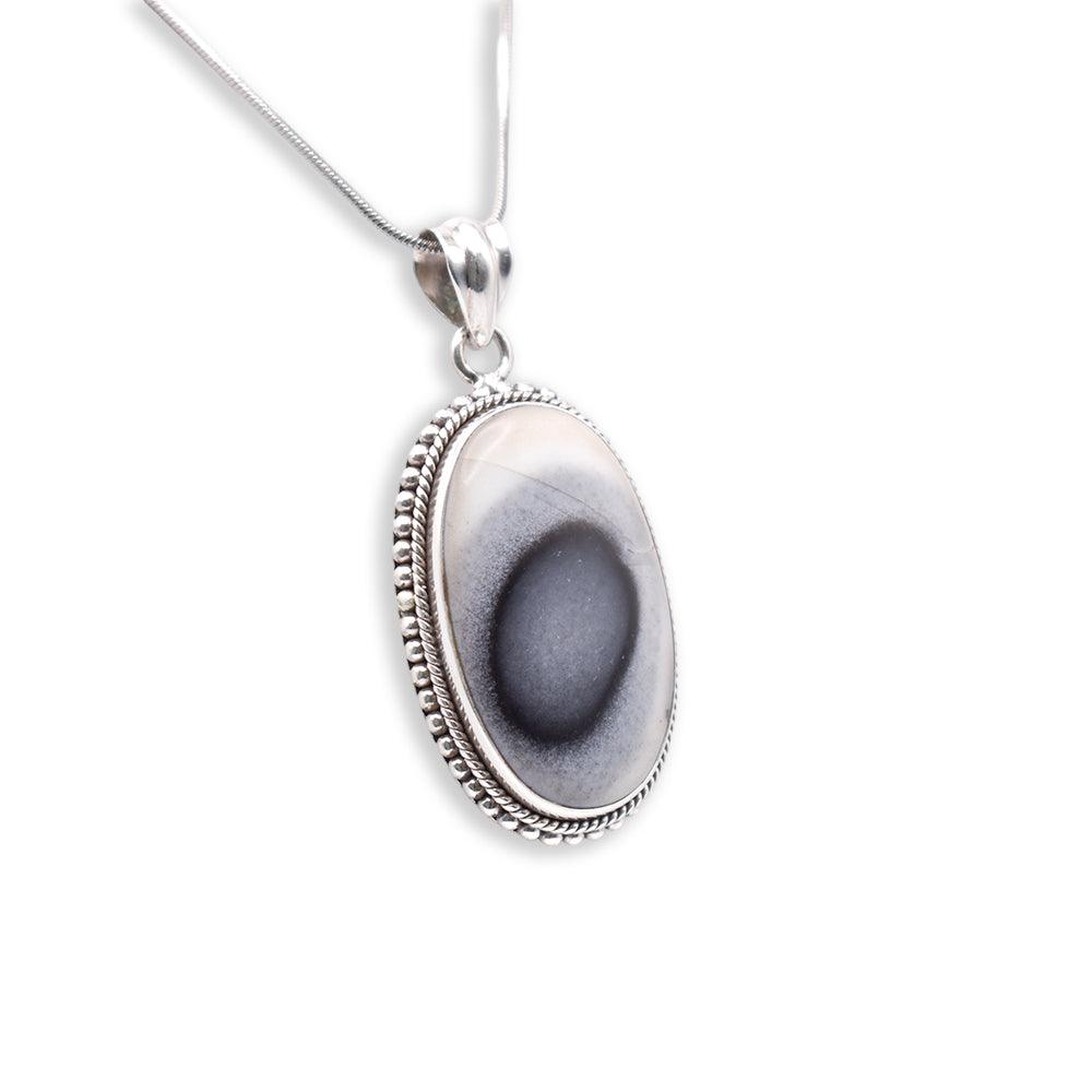 Oval shaped Dendritic Agate Pendant with silver chain on white background 