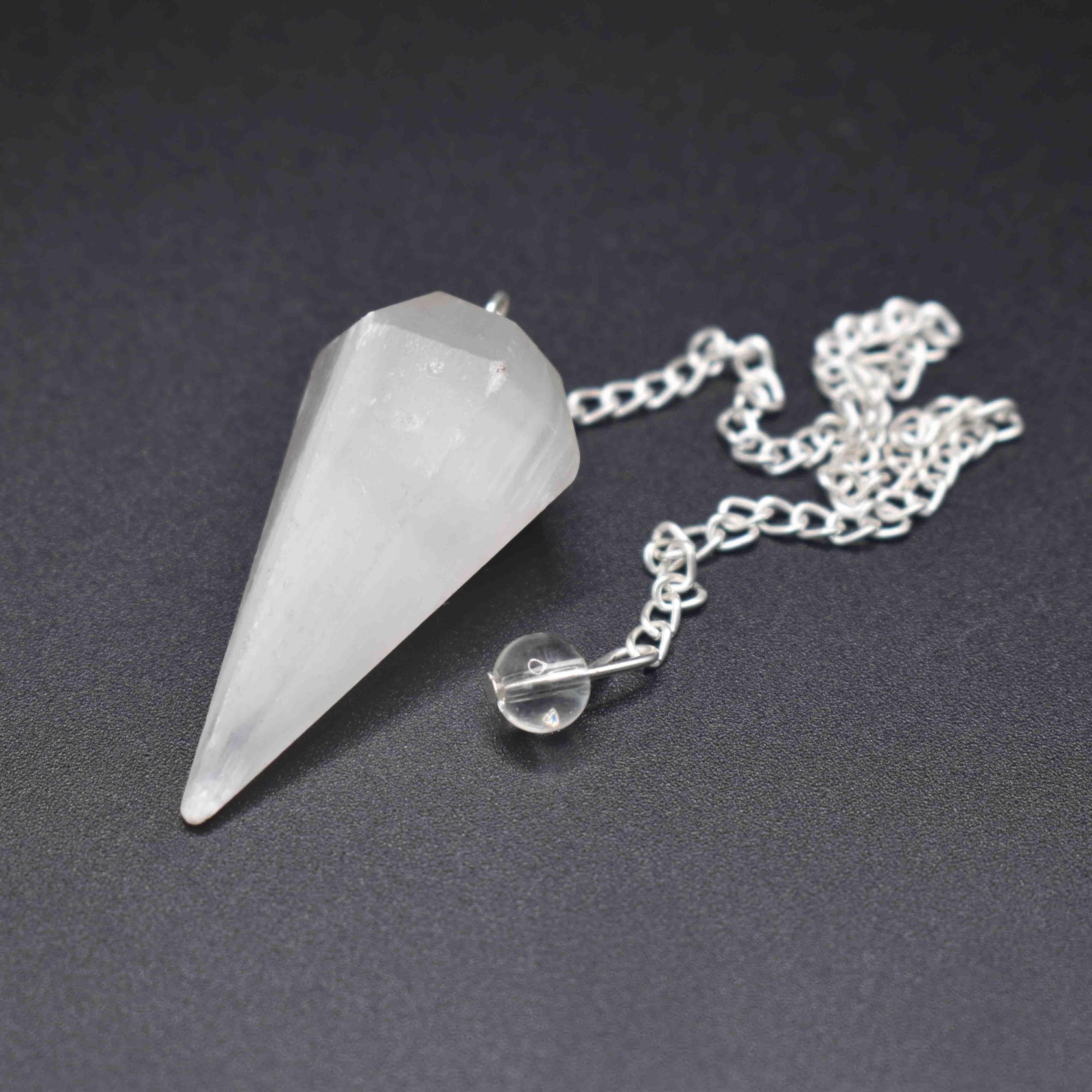 Selenite pendulum on black backgound front angle