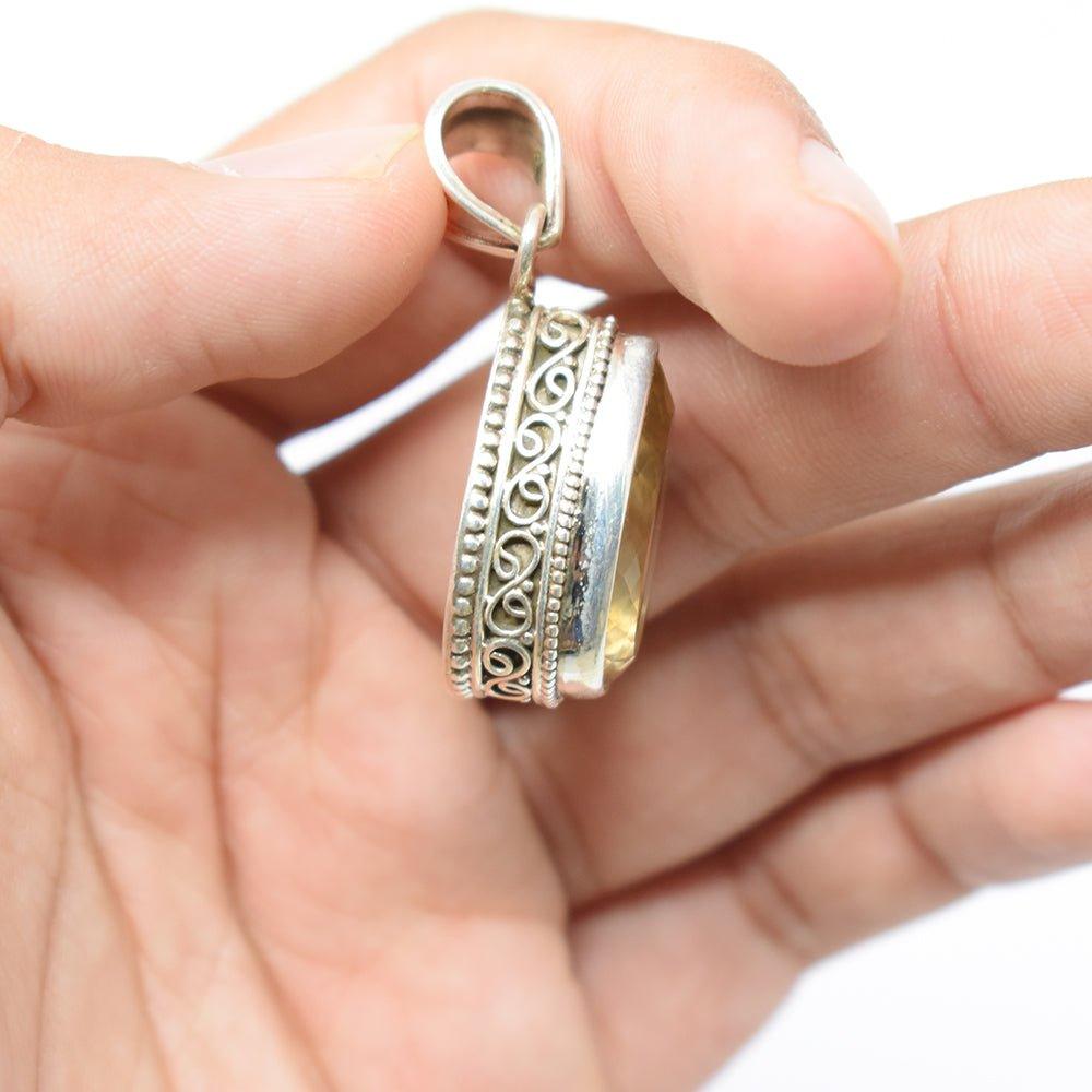 925 Sterling Silver Citrine pear shaped yellowish color Pendant side angle in hand on skin colored background