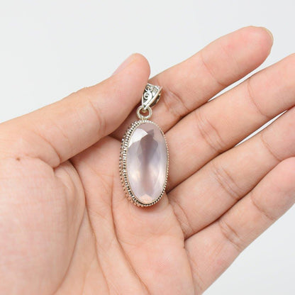 925 Sterling Silver Rose Quartz pink colored Pendant in hand on white background