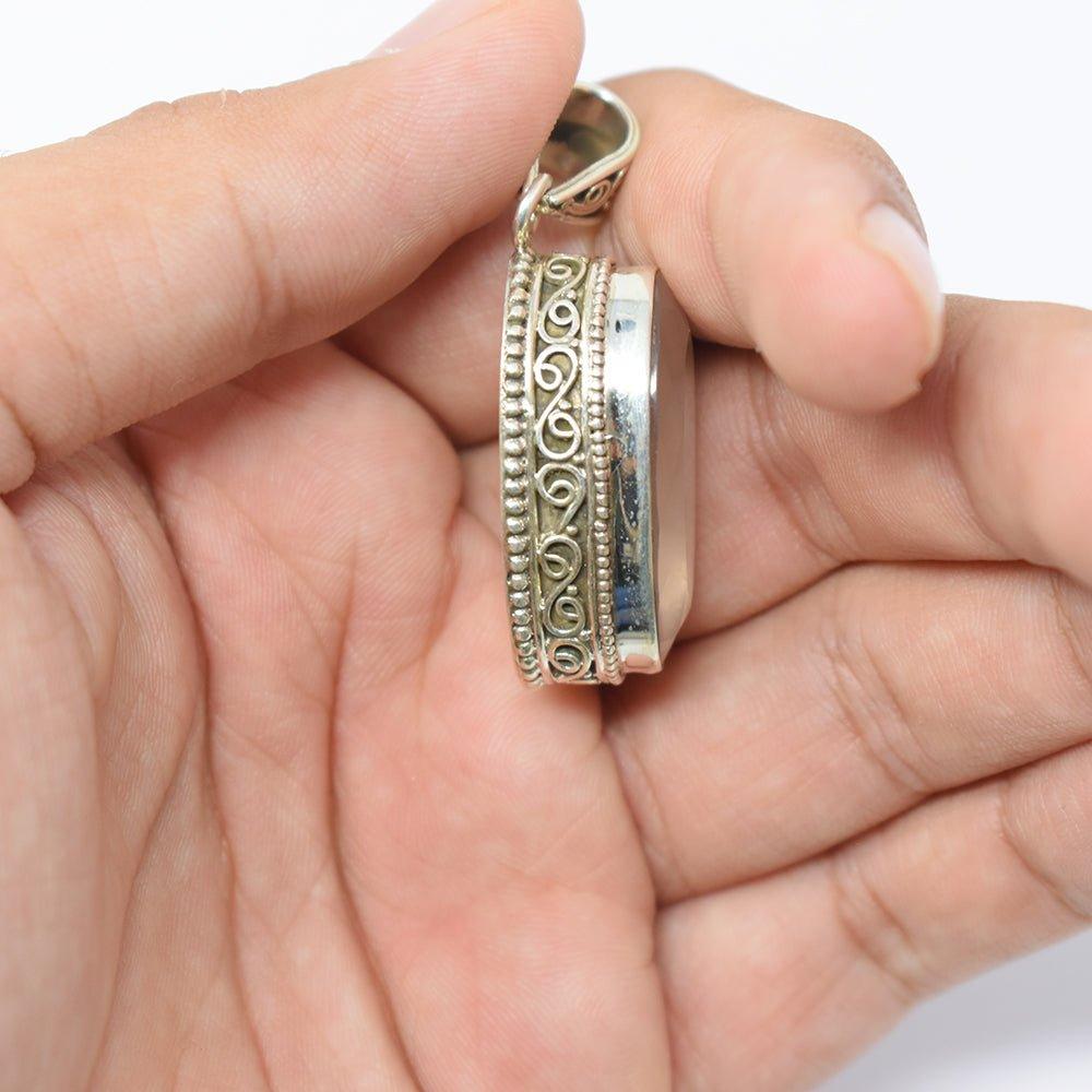 925 Sterling Silver Rose Quartz pink colored Pendant side angle in hand on skin colored background